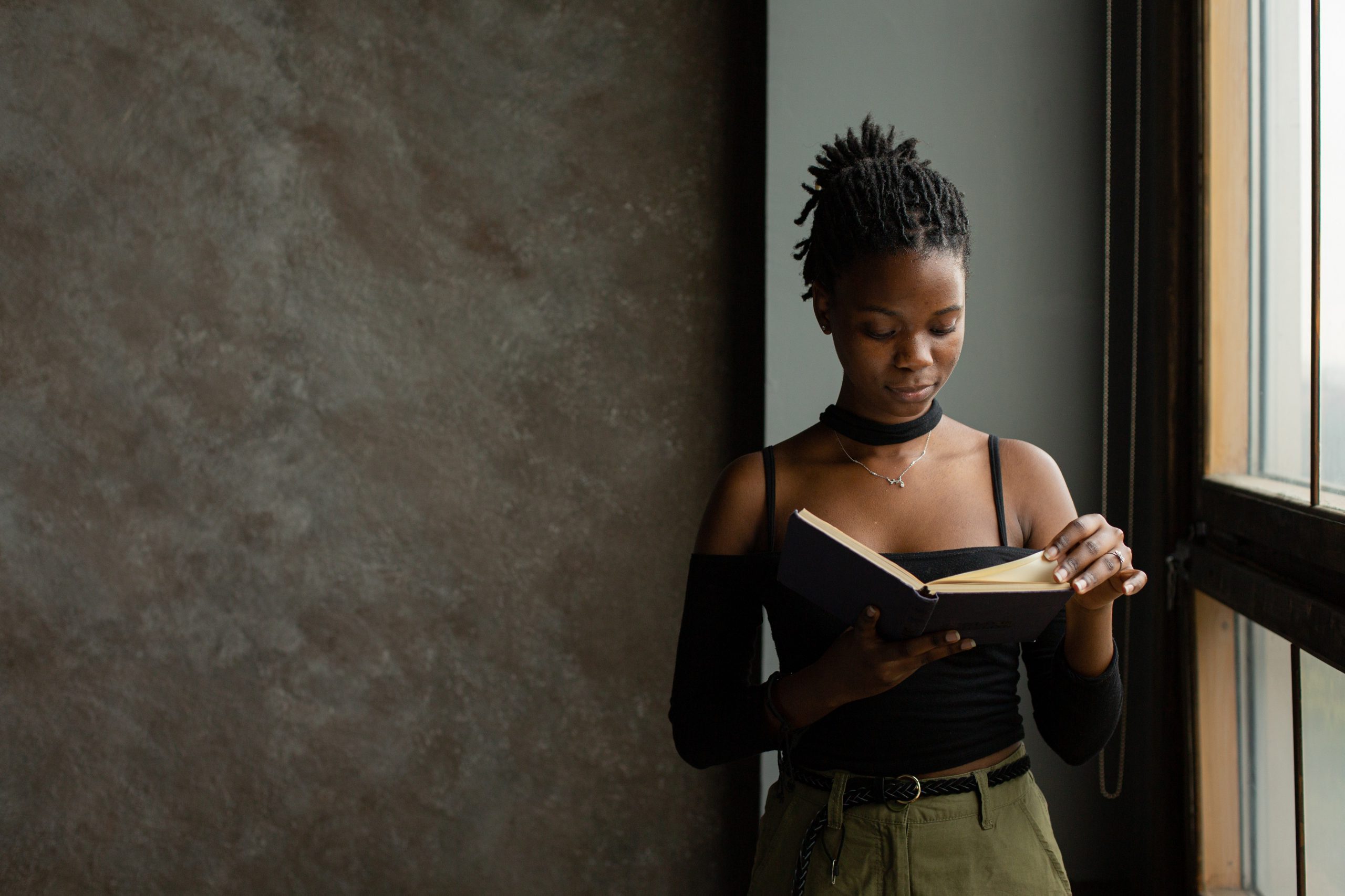 Black woman reading a book alone